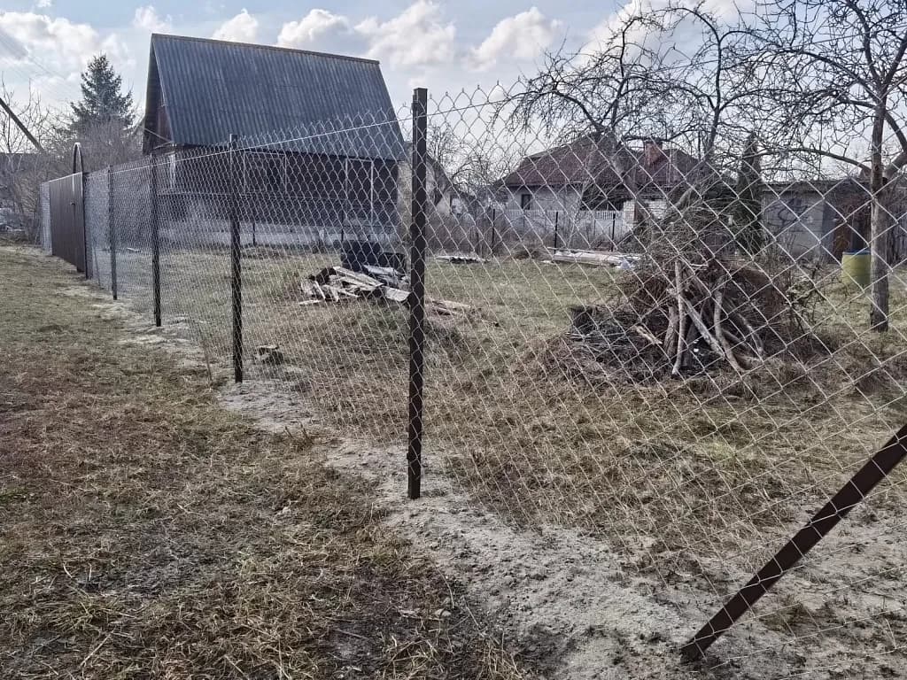 Установленный забор из сетки-рабицы на участке